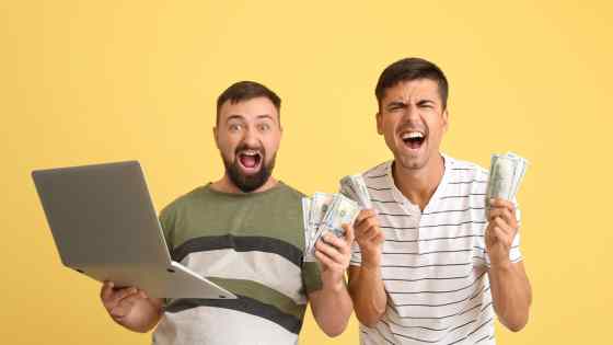 Online betting enthusiasts holding money and a laptop